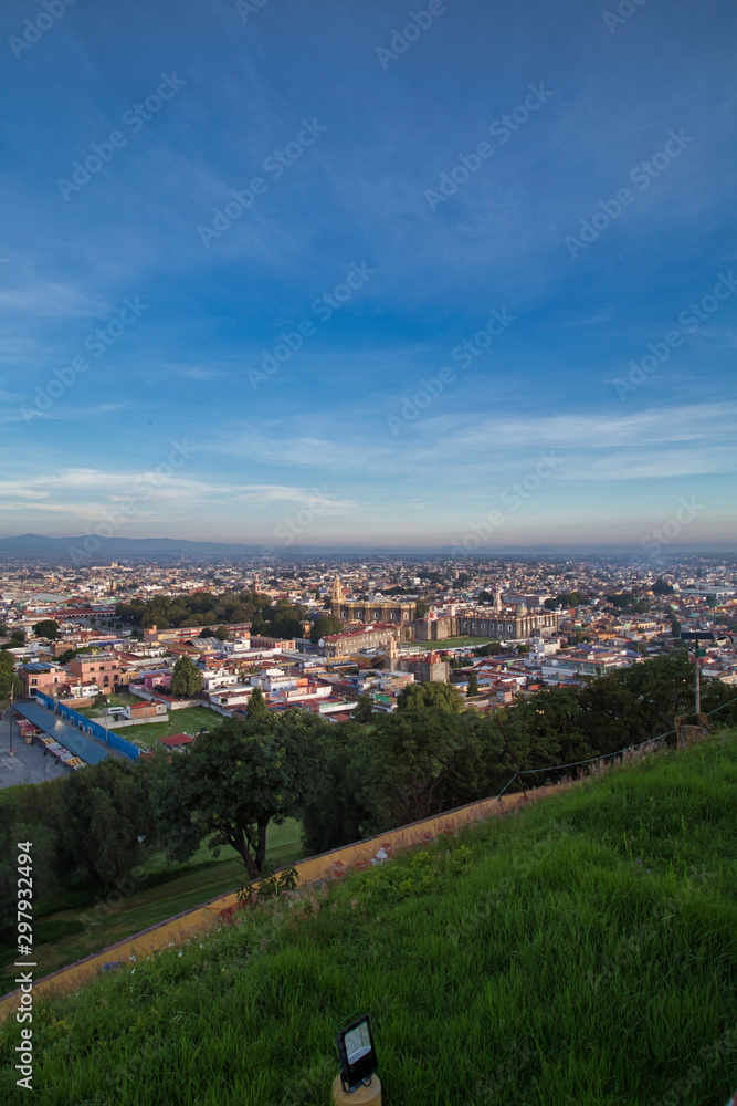 Panoramic view of the city, Popocatepetl volcano, San Gabriel Convent, the city is famous for its Great Pyramid, the largest archaeological site in the world at its base Panoramic view of the city, Popocatepetl volcano, San Gabriel Convent, the city is famous for its Great Pyramid, the largest archaeological site in the world at its base