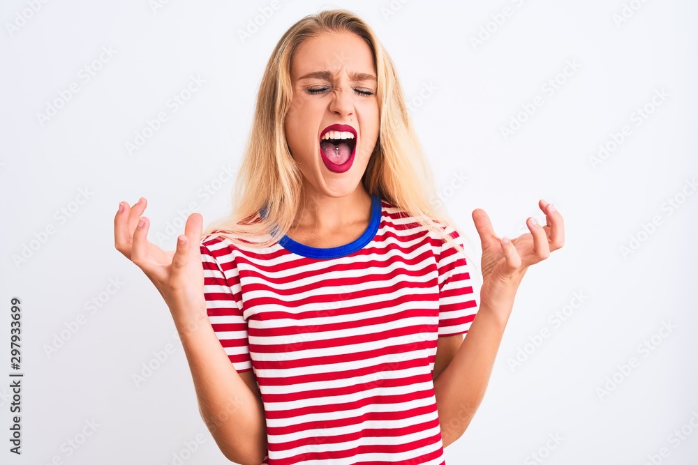 Young beautiful woman wearing red striped t-shirt standing over isolated white background celebrating mad and crazy for success with arms raised and closed eyes screaming excited. Winner concept Young beautiful woman wearing red striped t-shirt standing over isolated white background celebrating mad and crazy for success with arms raised and closed eyes screaming excited. Winner concept