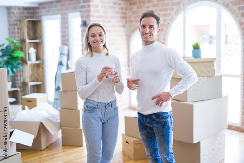 Young beautiful couple standing drinking cup of coffee at new home around cardboard boxes © Krakenimages.com