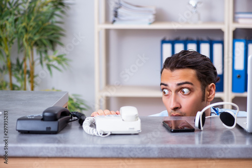 Foto Young male travel agent working in the office
