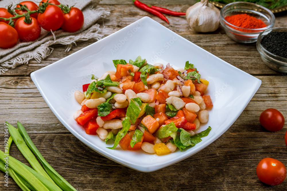 vegetable salad with white beans on wooden table vegetable salad with white beans on wooden table