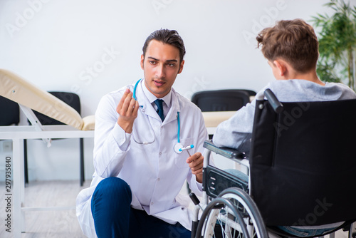 Young male doctor pediatrist and boy in wheel-chair © Elnur