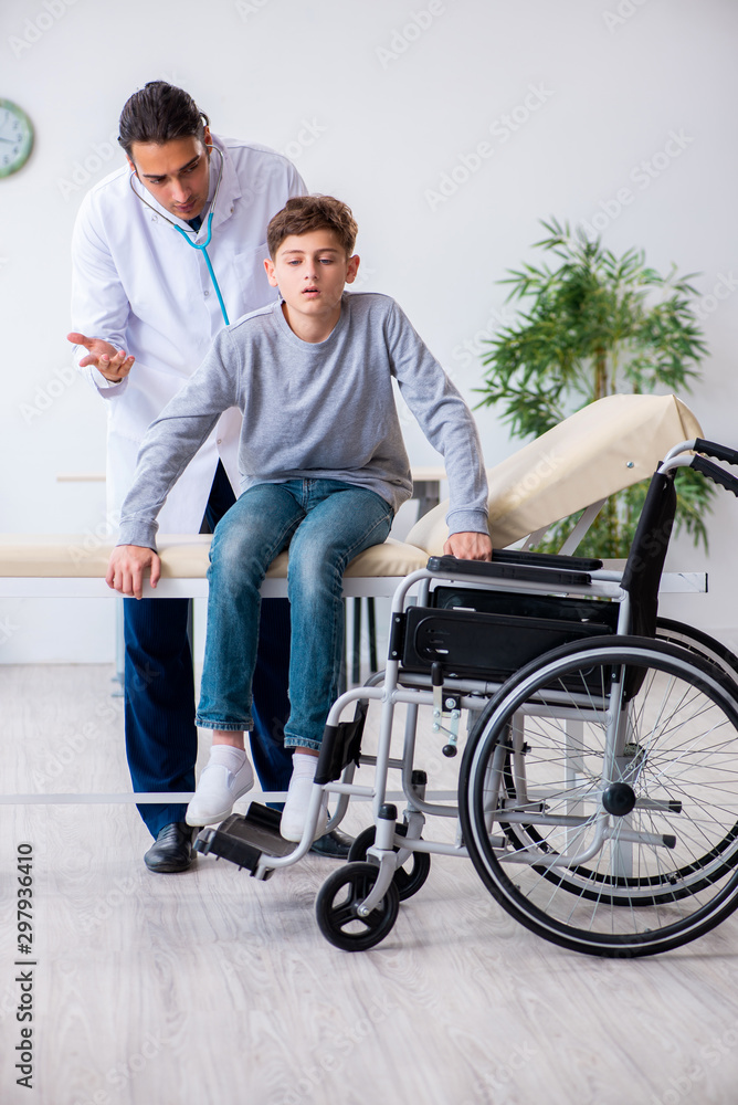 Young male doctor pediatrist and boy in wheel-chair Young male doctor pediatrist and boy in wheel-chair