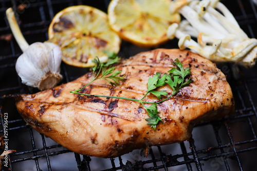 Chicken breast grilled with garlic chilli herbs and spices and lemon on grill top view - Roast BBQ chicken breast steak