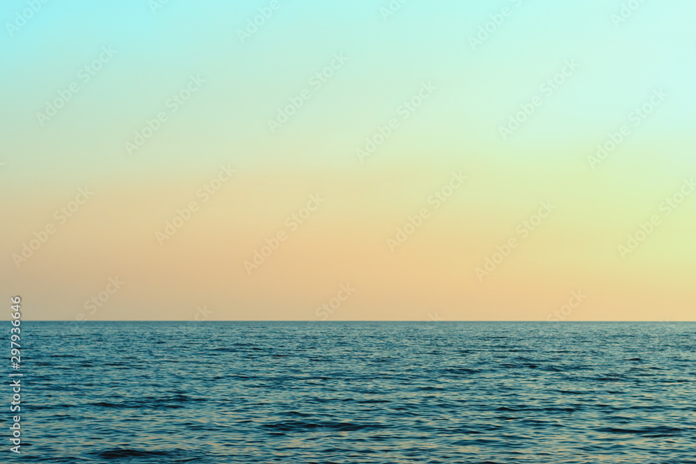 Bright sunset against the sky and the sea. Sunset on the beach. Beautiful sunset over a calm ocean or sea.