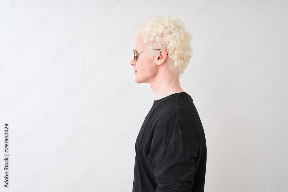 Young albino man wearing black t-shirt and sunglasess standing over isolated white background looking to side, relax profile pose with natural face with confident smile.