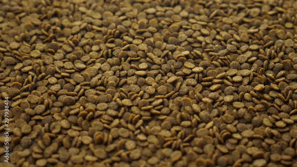 Brown granular fish feed for service feeding aquarium pets. Animal care or pet zoo store concept Brown granular fish feed for service feeding aquarium pets. Animal care or pet zoo store concept