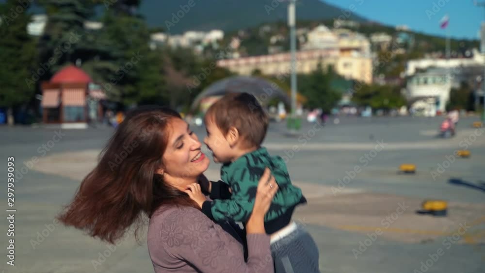 A young mother and her son are walking in the city A young mother and her son are walking in the city
