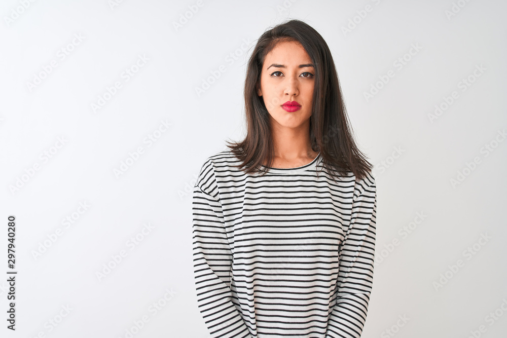 Obraz premium Young beautiful chinese woman wearing striped t-shirt standing over isolated white background Relaxed with serious expression on face. Simple and natural looking at the camera.