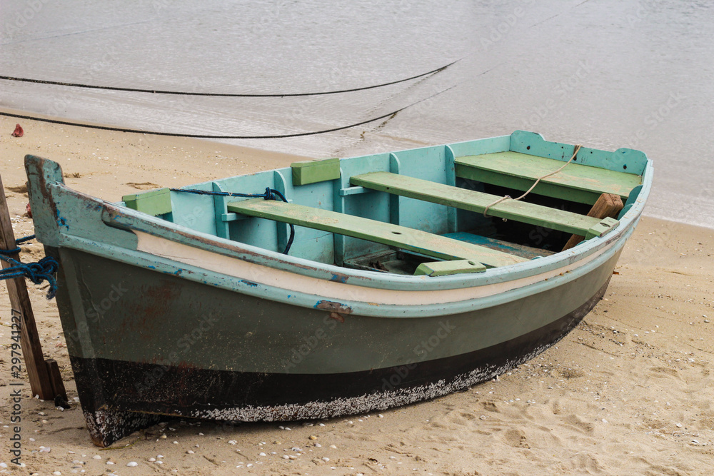 mint green wooden boat on beach sand - closeup