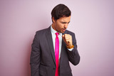 Young handsome businessman wearing suit and tie standing over isolated pink background feeling unwell and coughing as symptom for cold or bronchitis. Healthcare concept.