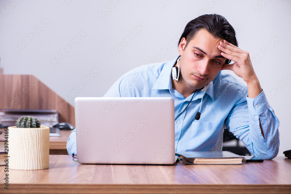 Call center operator working at his desk Call center operator working at his desk