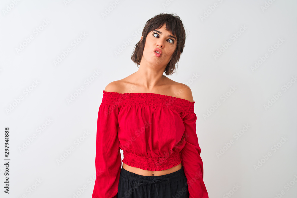 Young beautiful woman wearing red summer t-shirt standing over isolated white background making fish face with lips, crazy and comical gesture. Funny expression. Young beautiful woman wearing red summer t-shirt standing over isolated white background making fish face with lips, crazy and comical gesture. Funny expression.
