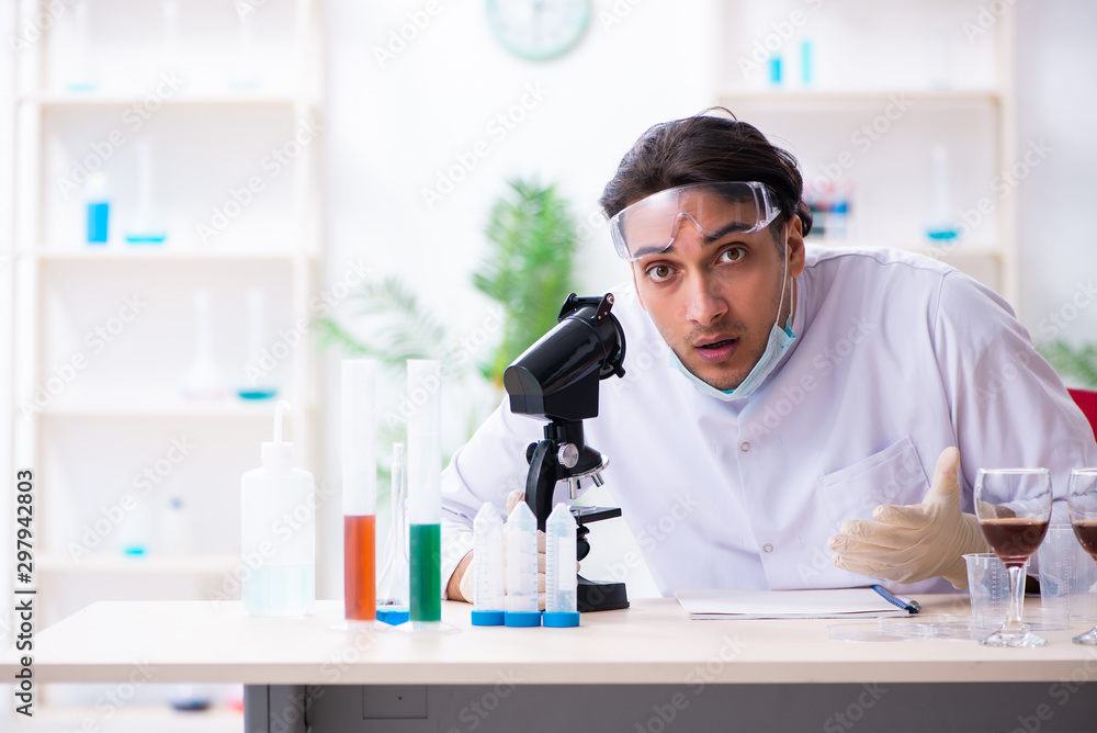 Male chemist examining wine samples at lab Male chemist examining wine samples at lab