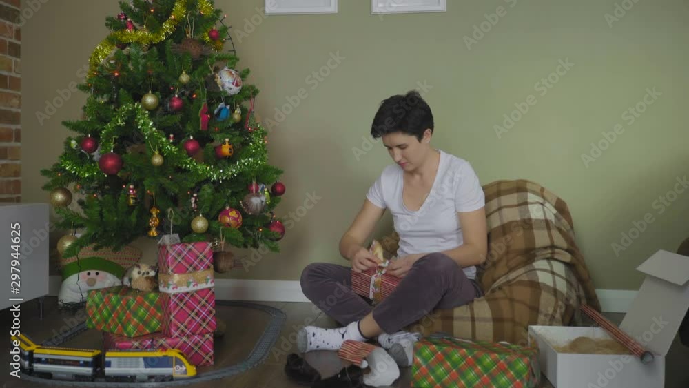 Young Woman Wrapping Christmas Gifts With Paper At Home Young Woman Wrapping Christmas Gifts With Paper At Home