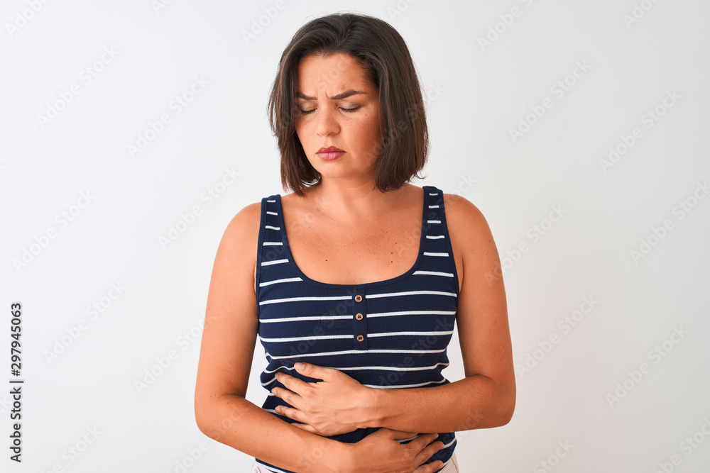 Obraz premium Young beautiful woman wearing blue striped t-shirt standing over isolated white background with hand on stomach because nausea, painful disease feeling unwell. Ache concept.
