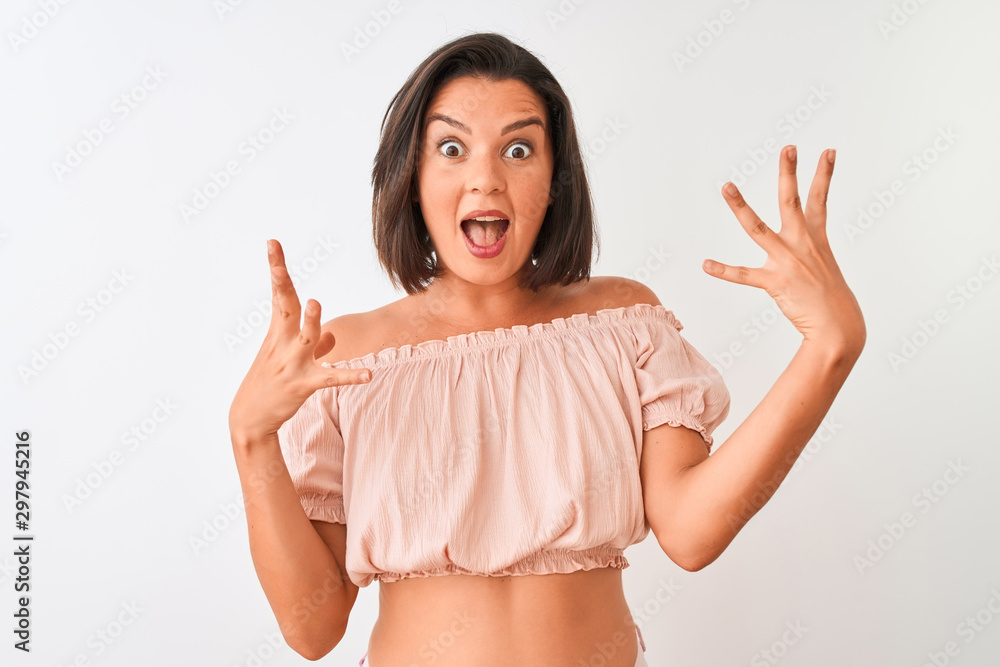 Young beautiful woman wearing casual t-shirt standing over isolated white background celebrating crazy and amazed for success with arms raised and open eyes screaming excited. Winner concept Young beautiful woman wearing casual t-shirt standing over isolated white background celebrating crazy and amazed for success with arms raised and open eyes screaming excited. Winner concept