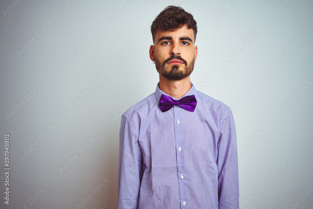 Young man with tattoo wearing purple shirt and bow tie over