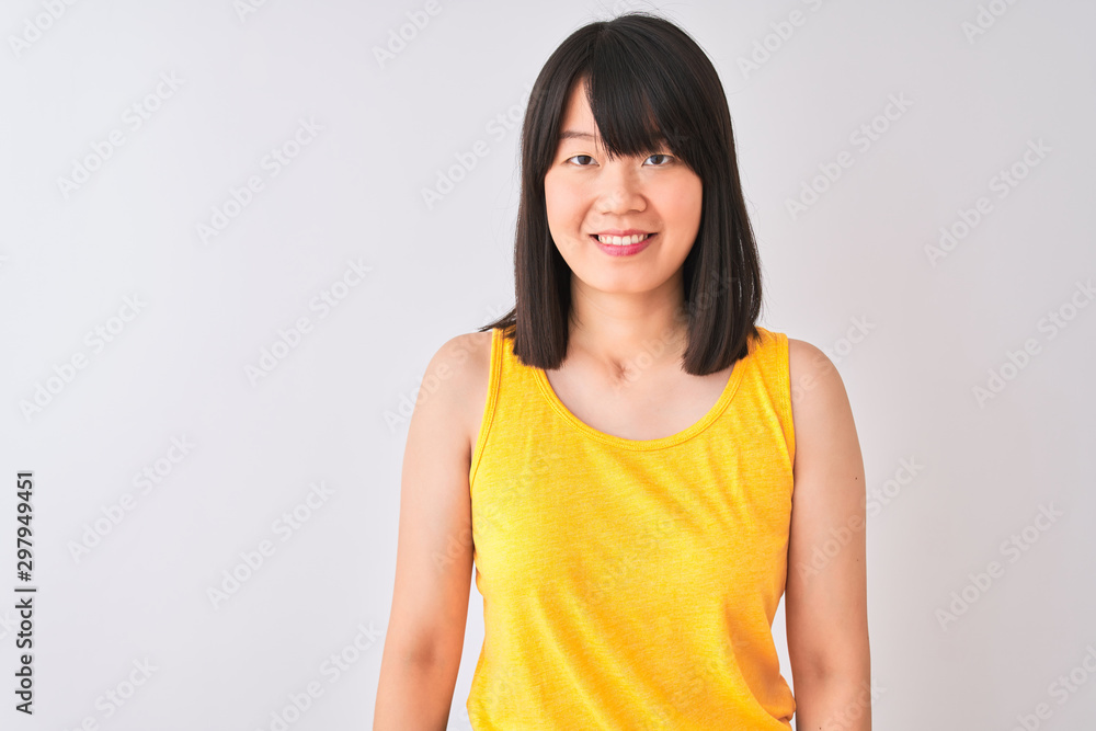 Young beautiful chinese woman wearing yellow t-shirt over isolated white background with a happy and cool smile on face. Lucky person. Young beautiful chinese woman wearing yellow t-shirt over isolated white background with a happy and cool smile on face. Lucky person.