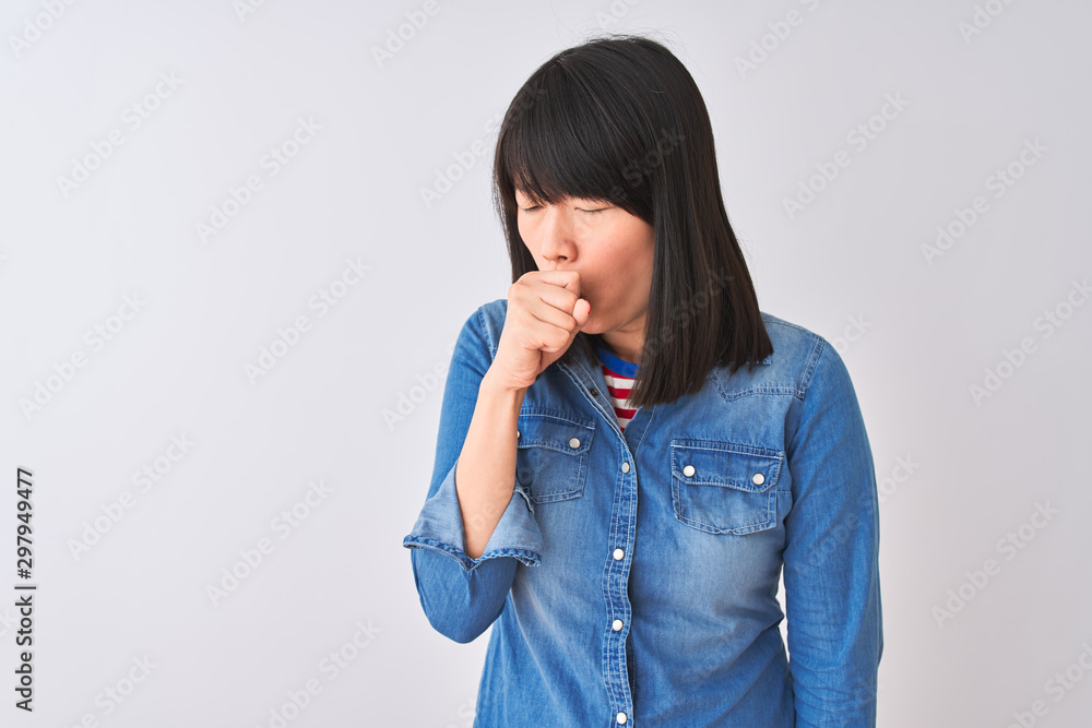 Young beautiful chinese woman wearing denim shirt over isolated white background feeling unwell and coughing as symptom for cold or bronchitis. Healthcare concept. Young beautiful chinese woman wearing denim shirt over isolated white background feeling unwell and coughing as symptom for cold or bronchitis. Healthcare concept.