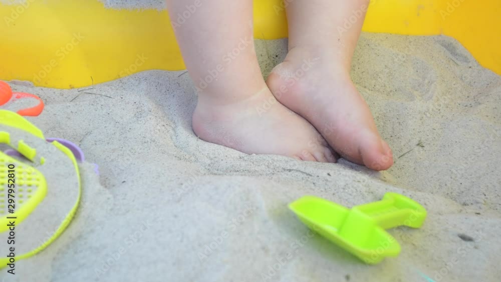 Small young Caucasian boy playing in sandpit on warm summer day Small young Caucasian boy playing in sandpit on warm summer day