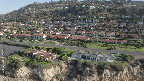 Palos Verdes luxury seaside villas atop coastal cliffs, aerial side truck view