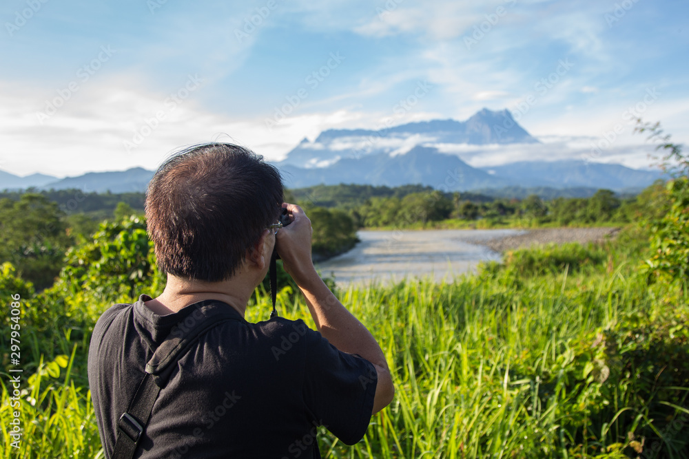 Asia Photographer man taking picture of beautiful Mount Kinabalu, Sabah, Borneo with nature environment Asia Photographer man taking picture of beautiful Mount Kinabalu, Sabah, Borneo with nature environment