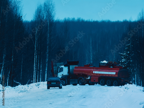 Timber truck full of wood driving along snowy road