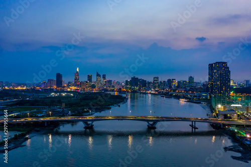 Classic aerial night river view of the Ho Chi Minh City, Vietnam financial district from Binh Thanh district with bridge across the Saigon river carrying evening traffic © Paul