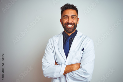 Valokuva Young smiling doctor standing against white background