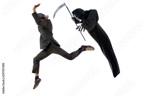 Man in a grim reaper halloween ghost costume having fun and scaring a grown businessman in a suit.  The image depicts pranks and being surprised.  Isolated on a white background.