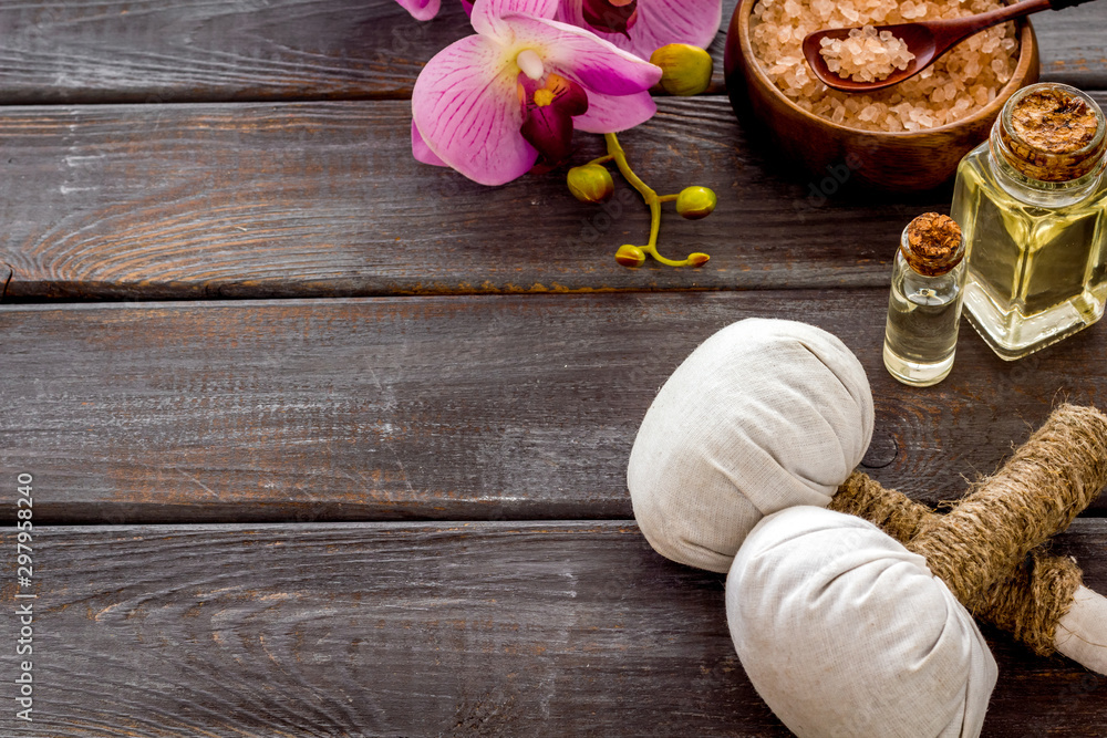 Massage thai herbal balls near spa accessories and orchids on dark wooden background copy space Massage thai herbal balls near spa accessories and orchids on dark wooden background copy space