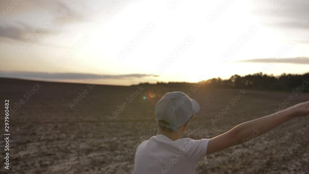 happy boy runs through a wheat field and rejoices at sunset, slow motion happy boy runs through a wheat field and rejoices at sunset, slow motion