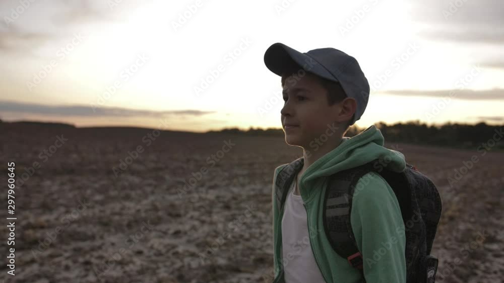 funny boy with backpack walking at sunset outdoors, travel concept funny boy with backpack walking at sunset outdoors, travel concept