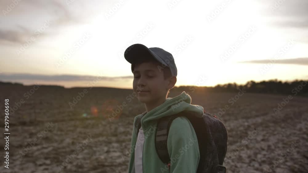 funny boy with backpack walking at sunset outdoors, travel concept funny boy with backpack walking at sunset outdoors, travel concept