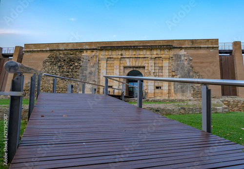 Wooden flooring on the bridge across the moat. Entrance to the old fortress. Historic building in Europe on a summer day on blue sky background. Preservation and popularization of historical monuments photo