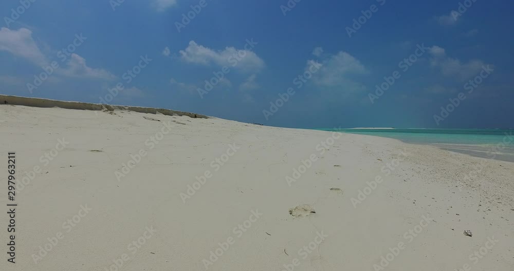 Footprints on the beautiful clean pristine white sand beach of the Caribbean Islands on a sunny day under clear blue sky with clouds and grass at background - Steady shot Footprints on the beautiful clean pristine white sand beach of the Caribbean Islands on a sunny day under clear blue sky with clouds and grass at background - Steady shot