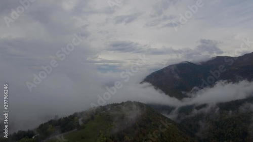 Wallpaper Mural footage of clouds and mist quickly forming and swirling over hills and mountains covered in Alpine autumn trees and forests. Torontodigital.ca