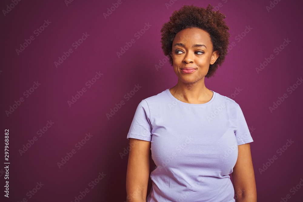 Young beautiful african american woman with afro hair over isolated purple background smiling looking to the side and staring away thinking. Young beautiful african american woman with afro hair over isolated purple background smiling looking to the side and staring away thinking.