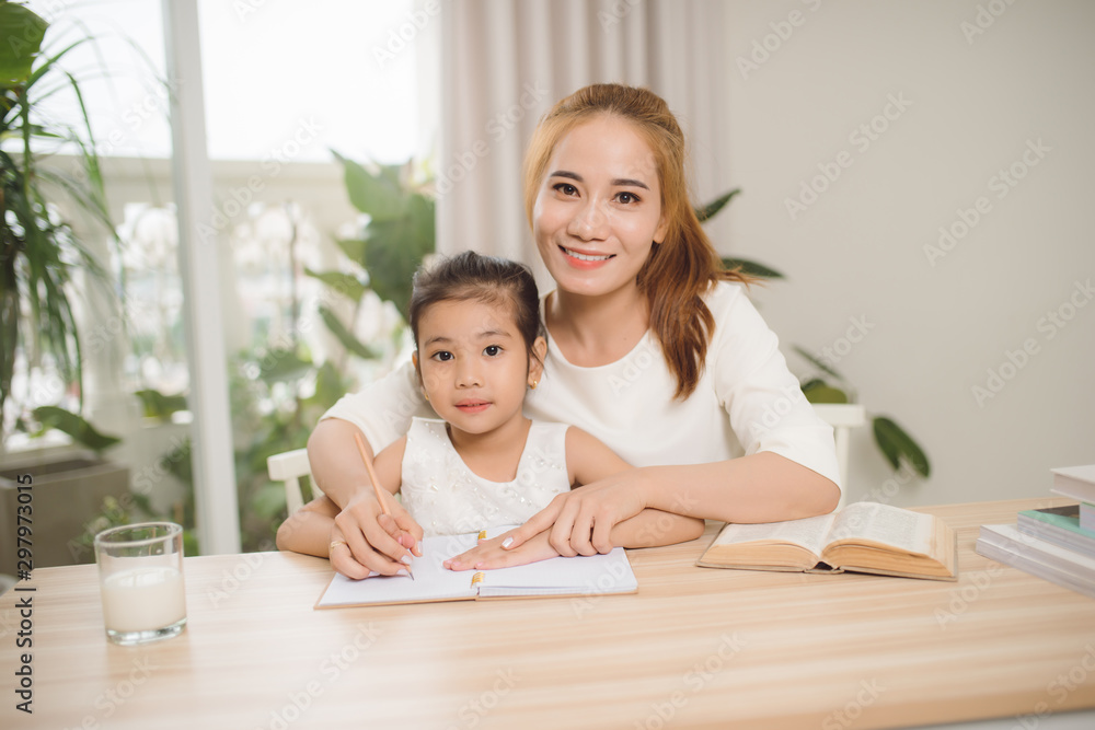 Mother teaching daughter how to write. Mother teaching daughter how to write.