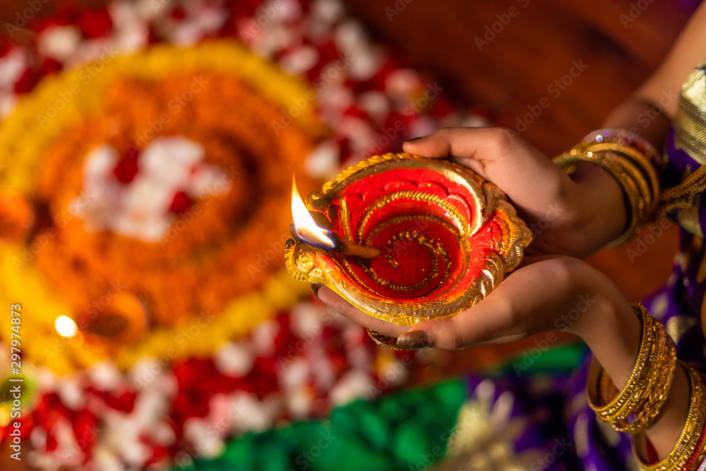 Φωτογραφία Beautiful young Indian woman in traditional sari dress holding a oil lamp light
