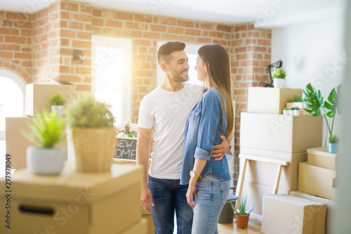 Beautiful young couple moving to a new house, smiling happy arround cardboard boxes © Krakenimages.com