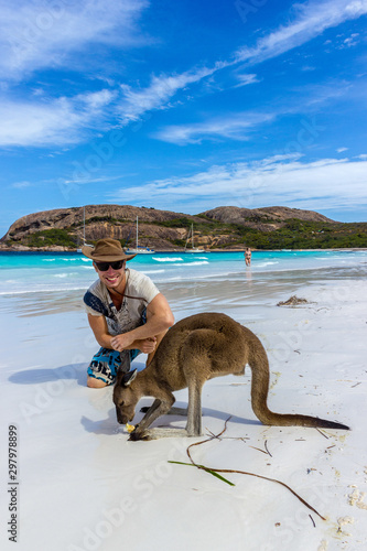 caucasian man with a beautiful Kangaroo at Lucky Bay Beach in the Cape Le Grand National Park near Esperance, Australia