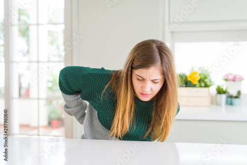 Young beautiful plus size woman wearing casual striped sweater Suffering of backache  touching back with hand  muscular pain