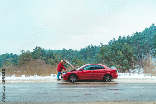 man standing near broken car at roadside snowed winter weather