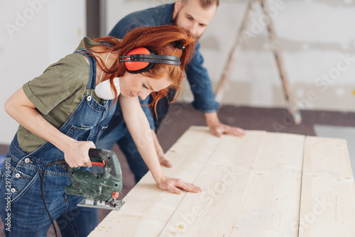 Fotografie Young woman preparing to use a power tool
