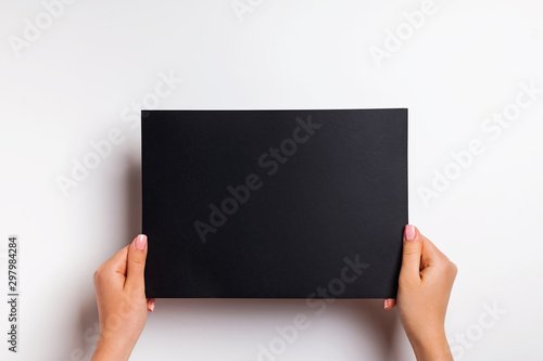 Woman's hands holding blank black color paper photo