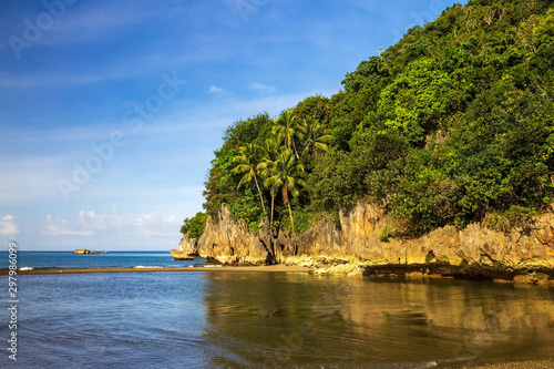 Limestone cliff covered by lush jungle on Paniman beach at sunset, municipality of Caramoan, Camarines Sur Province, Luzon, Philippines. Region for many Survivor TV shows filming.