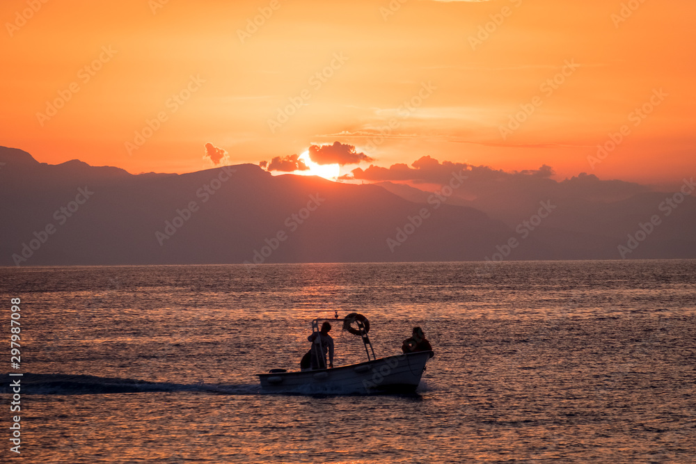 Fishing boat sailing in the sunset over the Tyrrhenian Sea in Cefalu, Sicily