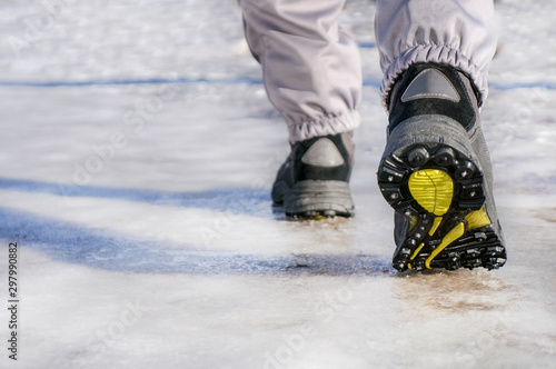 male or female winter boots walking on snowy sleet road photo